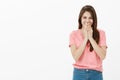 Shy and timid cute european female in pink t-shirt and jeans, chuckling and covering mouth with palm, laughing quietly