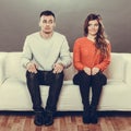 Shy woman and man sitting on sofa. First date. Royalty Free Stock Photo