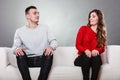 Shy woman and man sitting on sofa. First date. Royalty Free Stock Photo