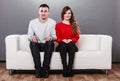 Shy woman and man sitting on sofa. First date. Royalty Free Stock Photo