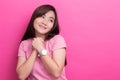 Shy woman smiling over pink background