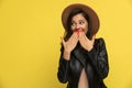 Shy young woman in leather jacket covering mouth with hands Royalty Free Stock Photo