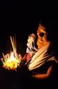 theravada buddhist pilgrim woman with a flower and candle raft during a religious holy celebration