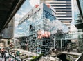 Siam Discovery department store. Modern glass windows building that reflected cloud and sky with traffic in Bangkok, Thailand.