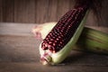 Siam Ruby Queen is super sweet corn with red color, can be eaten fresh place overlap and place on the wood table background