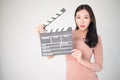 sian woman holding movie clapper board isolated on white background. Cinematography, communication arts, casting, audition, movie Royalty Free Stock Photo