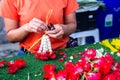 Sian woman staff is stringing flower garlands in flower shop Royalty Free Stock Photo