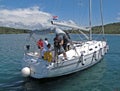 Sibenic, Croatia - may 8, 2015: Guys mooring a sailing yacht at a bay of Island with green coast. Training of yachting school. Lux Royalty Free Stock Photo