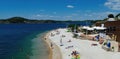 View on white sand pebble beach with islands background against blue summer sky Royalty Free Stock Photo