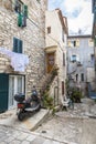 SIBENIK, CROATIA - OCTOBER 2, 2018: A small courtyard with medieval houses, drying linen and a motorbike