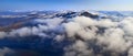 Aerial view mountain landscape with peaks covered by snow and clouds Royalty Free Stock Photo