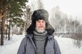 Siberian Russian man with a beard in hoarfrost in freezing cold in the winter freezes and wears a hat with a earflap Royalty Free Stock Photo