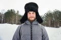 Siberian Russian man with a beard in hoarfrost in freezing cold in the winter freezes and wears a hat with a earflap Royalty Free Stock Photo