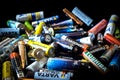 Used disposable drain batteries of various size and color on black background