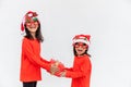 Sibling Asian girls in red Santa hat with gift boxes on white background