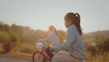 Sibling asian girls riding a bicycle and enjoying with nature together with sunrise in the morning time.