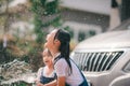 Sibling Asian girls wash their cars and have fun playing indoors on a hot summer day