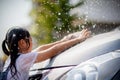 Sibling Asian girls wash their cars and have fun playing indoors on a hot summer day