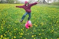 Sibling brother playing leapfrog game with her little sister on spring dandelions meadow