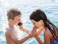 Sibling sharing ice cream by the pool