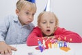 Siblings blowing birthday candles at table Royalty Free Stock Photo