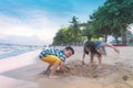 Siblings children is playing with wave and sand in Pattaya Beach Thailand Royalty Free Stock Photo