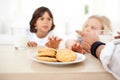 Siblings eating biscuits and drinking milk