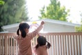 Siblings girl drawing rainbow looks through the window during covid-19 quarantine. stay at home social media campaign for corona