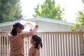 Siblings girl drawing rainbow looks through the window during covid-19 quarantine. stay at home social media campaign for corona