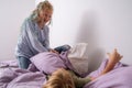 siblings having fun, laughing, boy and girl play pillow fight in messy childrens room, kids playing among the many toys Royalty Free Stock Photo