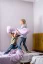 siblings having fun, laughing, boy and girl play pillow fight in messy childrens room, kids playing among the many toys Royalty Free Stock Photo
