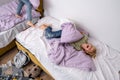 siblings having fun, laughing, boy and girl play pillow fight in messy childrens room, kids playing among the many toys Royalty Free Stock Photo