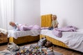 siblings having fun, laughing, boy and girl play pillow fight in messy childrens room, kids playing among the many toys Royalty Free Stock Photo