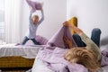 siblings having fun, laughing, boy and girl play pillow fight in messy childrens room, kids playing among the many toys Royalty Free Stock Photo