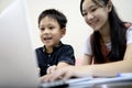 Siblings Kid boy and child girl are enjoying playing online game on laptop computer,asian sister,little brother having fun