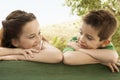 Siblings Leaning Against Wooden Railing