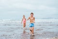 Siblings playing on beach, running, skipping, having fun. Smilling girl and boy on sandy beach of Canary islands Royalty Free Stock Photo