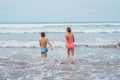 Siblings playing on beach, running, skipping, having fun on sandy beach of Canary islands. Concept of family beach Royalty Free Stock Photo