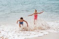 Siblings playing on beach, running, skipping, having fun. Smilling girl and boy on sandy beach with vulcanic rocks of Royalty Free Stock Photo