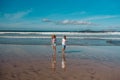 Siblings playing on beach, running, skipping in water. Smilling girl and boy on sandy beach of Canary islands. Concept Royalty Free Stock Photo