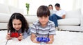 Siblings playing video games lying on the floor Royalty Free Stock Photo