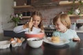 Siblings preparing cookie on worktop in kitchen