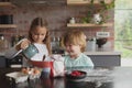 Siblings preparing cookie on worktop in kitchen