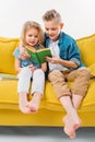 siblings reading book and sitting Royalty Free Stock Photo
