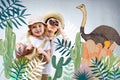 siblings in safari costumes hugging and looking in binoculars at cactuses Royalty Free Stock Photo