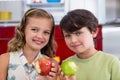 Siblings showing missing bite of apple in kitchen