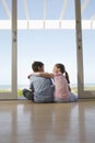 Siblings Sitting In Doorway Looking At Each Other Royalty Free Stock Photo