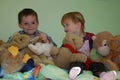 Siblings sitting in the middle of all her stuffed animals Royalty Free Stock Photo