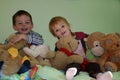 Siblings sitting in the middle of all her stuffed animals Royalty Free Stock Photo