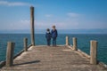 Siblings standing on a wooden pier